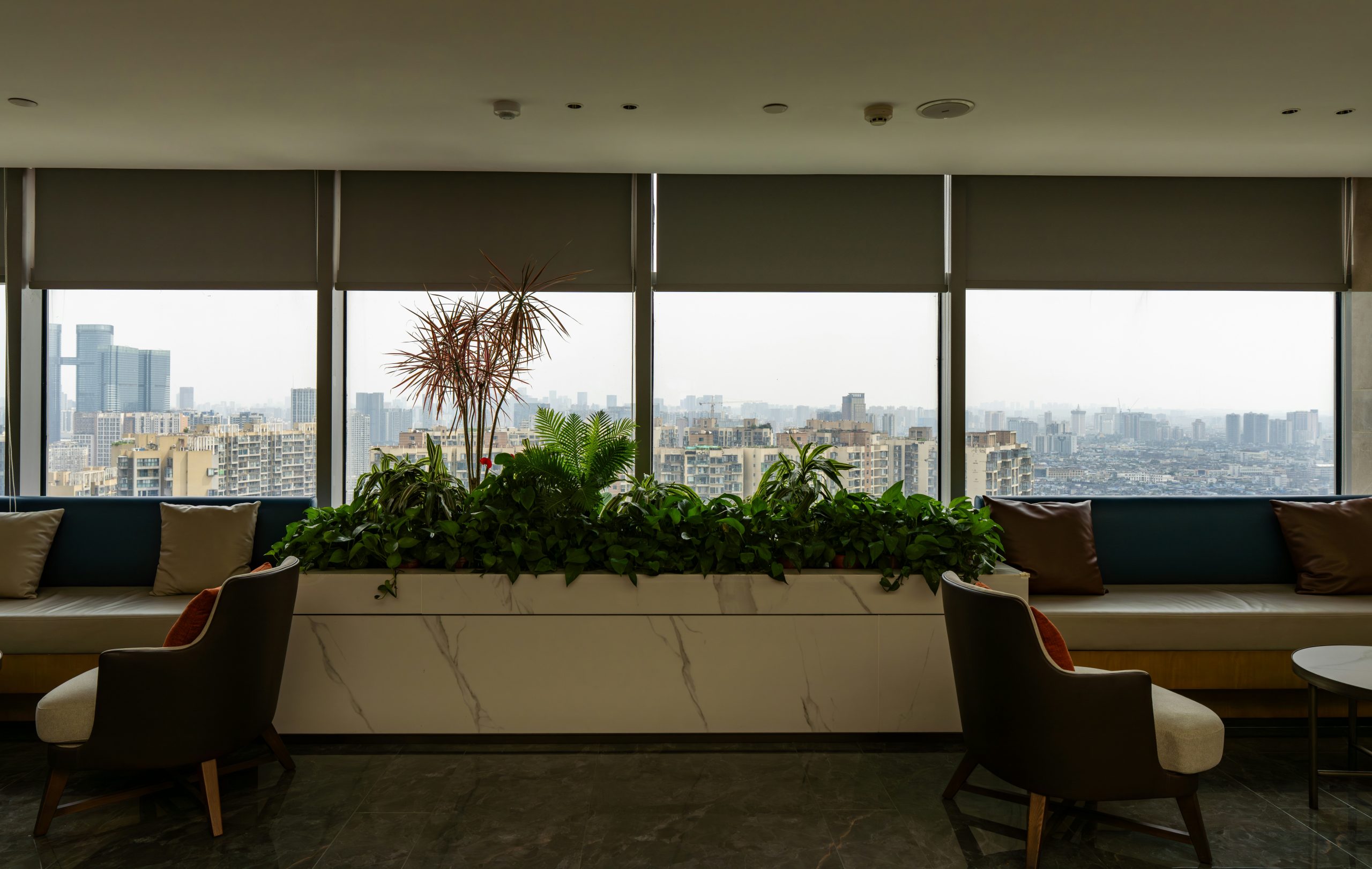 Modern high-rise condo lounge area with floor-to-ceiling windows and panoramic city views