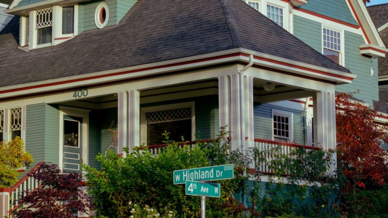 Craftsman-style house with a large front porch on a tree-lined street