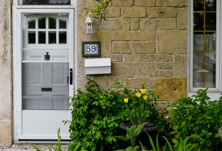 White front door of a home with a house number